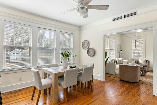 dining area with visible vents, wood-type flooring, baseboards, and ornamental molding