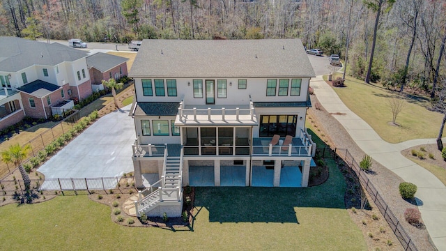 back of house with a sunroom, fence, stairs, roof with shingles, and a yard