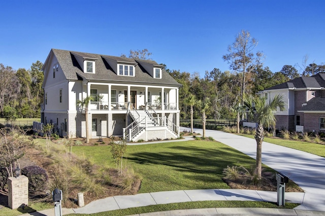 view of front facade featuring a porch, driveway, stairs, and a front lawn