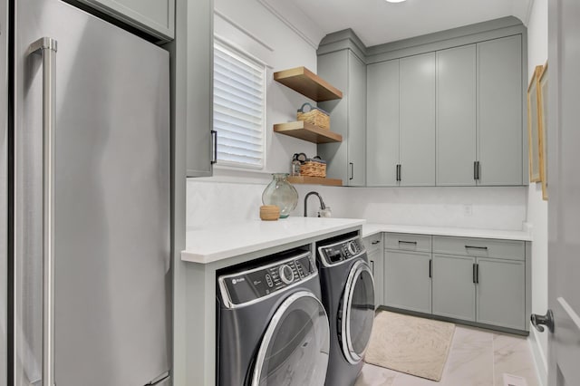 laundry room with marble finish floor, washer and dryer, and cabinet space
