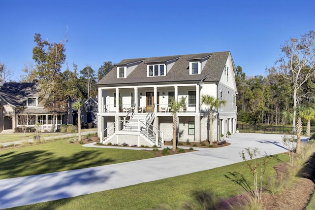 view of front of property with a garage, concrete driveway, stairway, a front yard, and covered porch