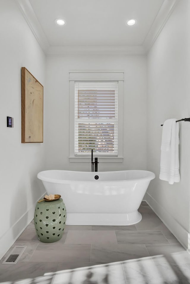 full bathroom with visible vents, a soaking tub, crown molding, baseboards, and recessed lighting