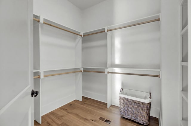 spacious closet featuring visible vents and wood finished floors