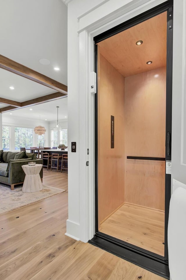 interior details featuring elevator, wood finished floors, recessed lighting, and beamed ceiling