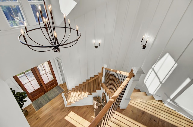 foyer entrance with a notable chandelier, stairs, and wood finished floors