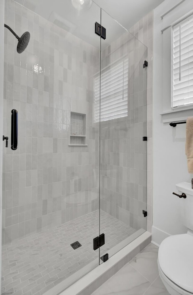 full bath featuring marble finish floor, toilet, baseboards, and a shower stall