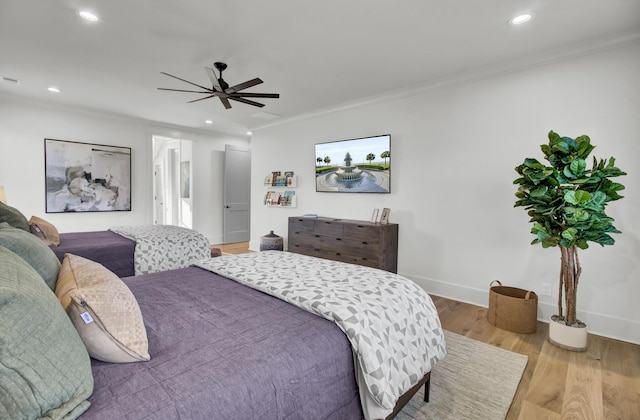 bedroom with wood finished floors, recessed lighting, and crown molding