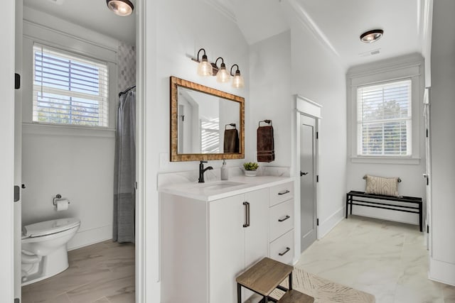 bathroom with marble finish floor, toilet, and plenty of natural light