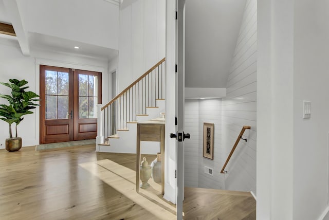 entryway featuring a high ceiling, wood finished floors, and french doors