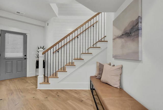 foyer with wood finished floors, baseboards, stairs, and visible vents