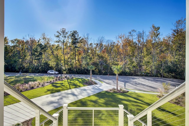 exterior space featuring a wooded view and a yard