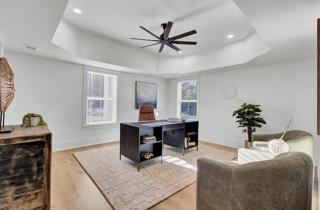 office featuring visible vents, ceiling fan, and a raised ceiling