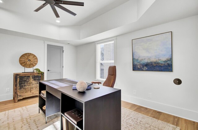office area featuring a ceiling fan, light wood-style flooring, and baseboards