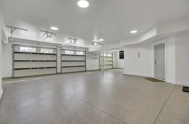 garage featuring baseboards, a garage door opener, and electric panel