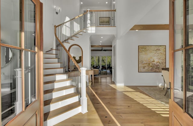entrance foyer with a high ceiling, baseboards, stairs, and wood finished floors
