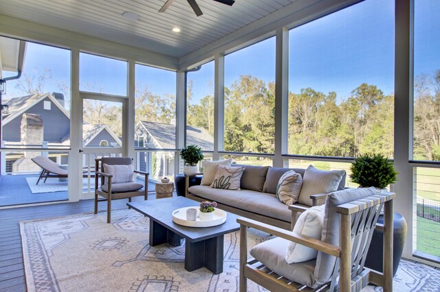 sunroom with outdoor lounge area, floor to ceiling windows, wood finished floors, and ceiling fan