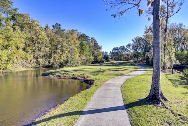 view of home's community featuring a lawn and a water view