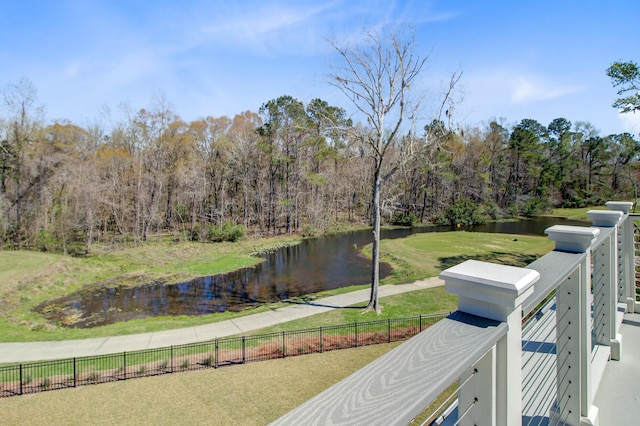 view of water feature with a wooded view and fence