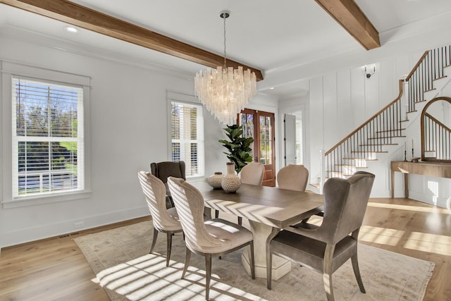 dining space featuring a chandelier, beamed ceiling, baseboards, stairs, and wood finished floors