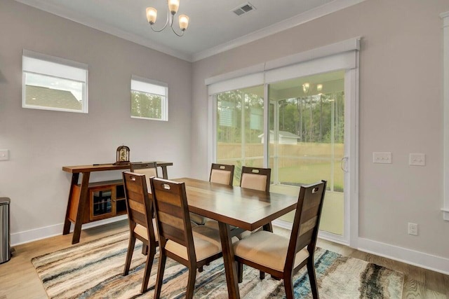 dining room with a chandelier, light hardwood / wood-style flooring, and ornamental molding