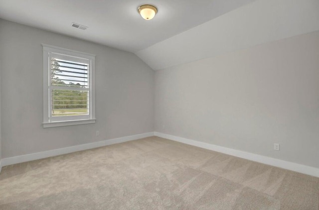 bonus room featuring vaulted ceiling and light colored carpet