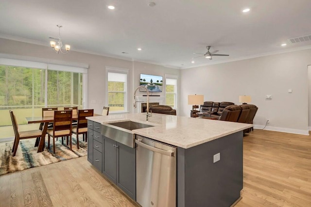 kitchen featuring stainless steel dishwasher, decorative light fixtures, light hardwood / wood-style floors, and a kitchen island with sink