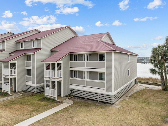 back of property with a yard and a water view