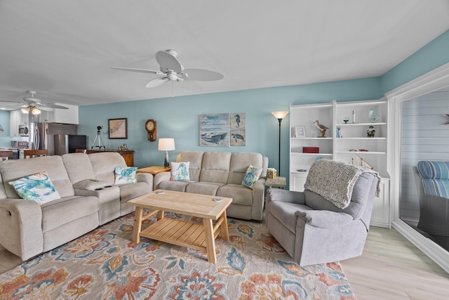 living room with ceiling fan and light hardwood / wood-style flooring