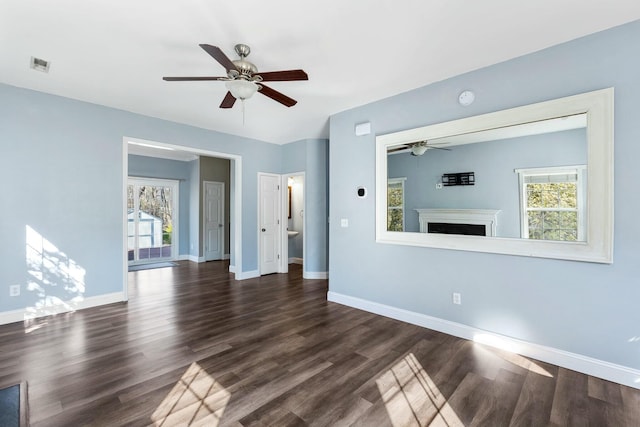 unfurnished living room with a fireplace, visible vents, dark wood-type flooring, ceiling fan, and baseboards