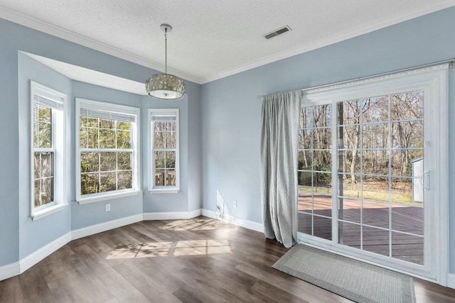 unfurnished dining area with visible vents, a textured ceiling, baseboards, and wood finished floors