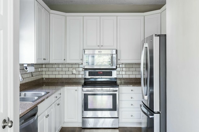 kitchen with white cabinetry, appliances with stainless steel finishes, backsplash, and a sink