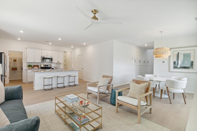 living room with recessed lighting, baseboards, light wood-type flooring, and a ceiling fan