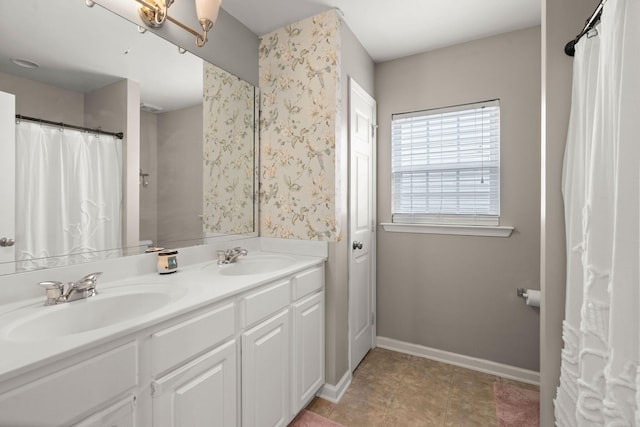 full bathroom featuring double vanity, baseboards, a sink, and tile patterned floors