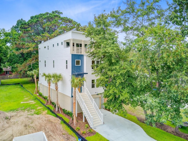 501 Joseph St, Charleston, SC 29412 - view of front of home with a front yard, an attached garage, driveway, stairs, and view of wooded area