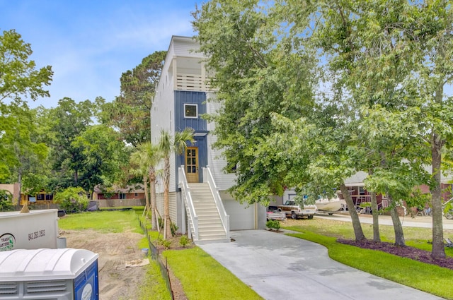 501 Joseph St, Charleston, SC 29412 - view of front of property with a garage, concrete driveway, a front lawn, and stairway
