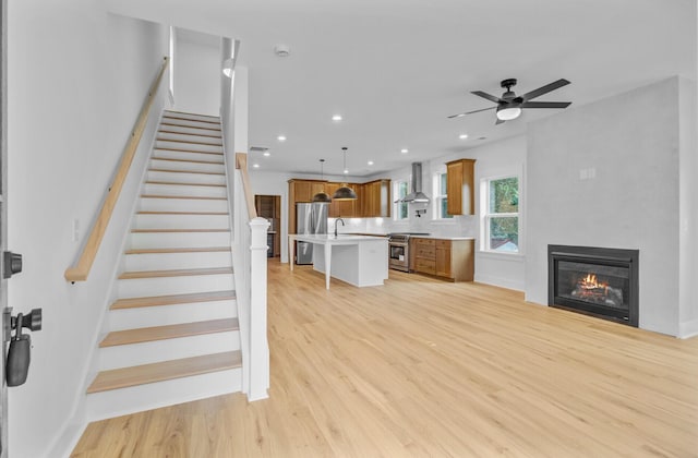 501 Joseph St, Charleston, SC 29412 - unfurnished living room featuring light wood-style flooring, a ceiling fan, stairs, a glass covered fireplace, and recessed lighting
