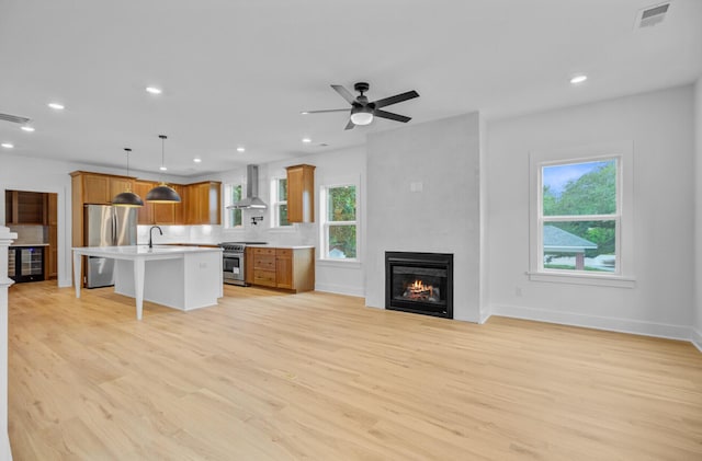 501 Joseph St, Charleston, SC 29412 - unfurnished living room featuring a fireplace, light wood finished floors, recessed lighting, wine cooler, and ceiling fan