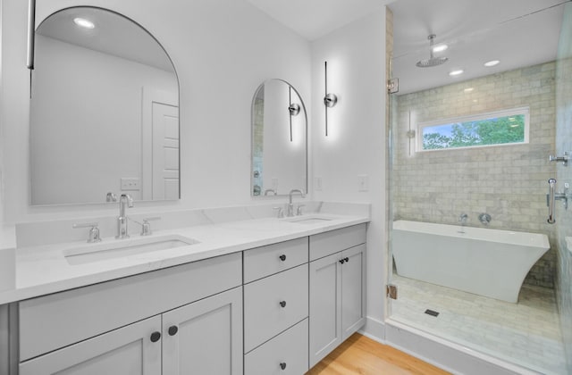 501 Joseph St, Charleston, SC 29412 - full bathroom featuring a freestanding tub, double vanity, a shower stall, wood finished floors, and recessed lighting