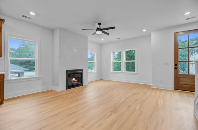 501 Joseph St, Charleston, SC 29412 - unfurnished living room featuring healthy amount of natural light, light wood finished floors, a ceiling fan, a glass covered fireplace, and recessed lighting