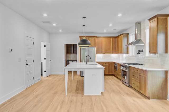 501 Joseph St, Charleston, SC 29412 - kitchen with stainless steel appliances, wall chimney range hood, light wood-type flooring, backsplash, and light countertops