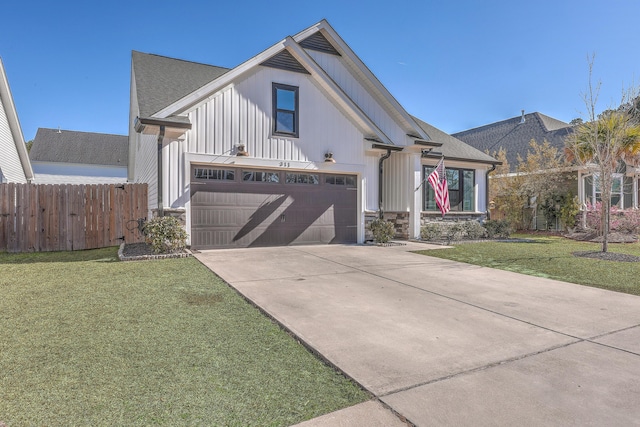 view of front facade with a garage, concrete driveway, a front lawn, and fence