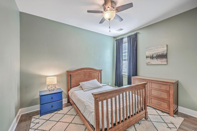 bedroom featuring a ceiling fan, light wood-style flooring, baseboards, and visible vents