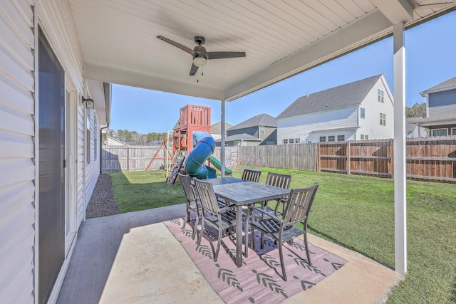 view of patio featuring outdoor dining space, a playground, a ceiling fan, and a fenced backyard