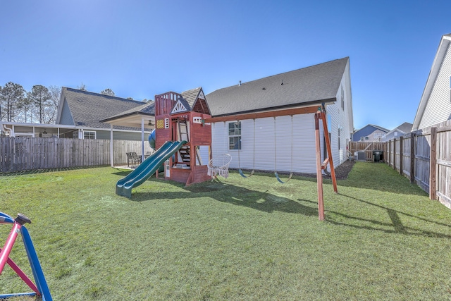 view of jungle gym featuring a yard, a fenced backyard, and central AC