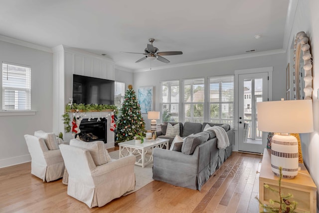 living room featuring ceiling fan, wood-type flooring, and ornamental molding