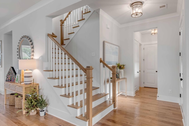 entryway featuring a chandelier, light hardwood / wood-style flooring, and ornamental molding