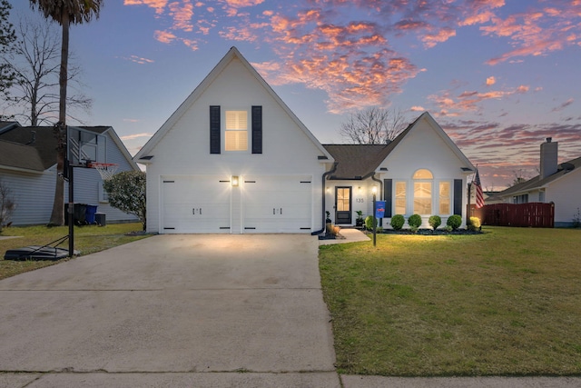 view of front of home featuring concrete driveway, a yard, fence, and a garage