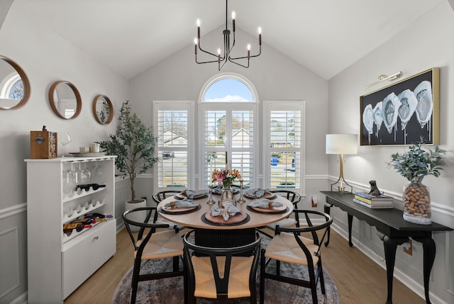 dining space featuring lofted ceiling, an inviting chandelier, and wood finished floors