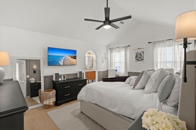 bedroom featuring visible vents, ceiling fan, high vaulted ceiling, light wood-style floors, and ensuite bath