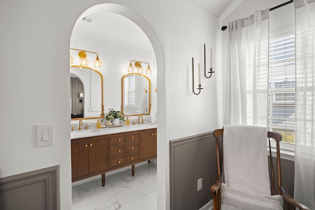 bathroom featuring a sink, plenty of natural light, marble finish floor, and double vanity